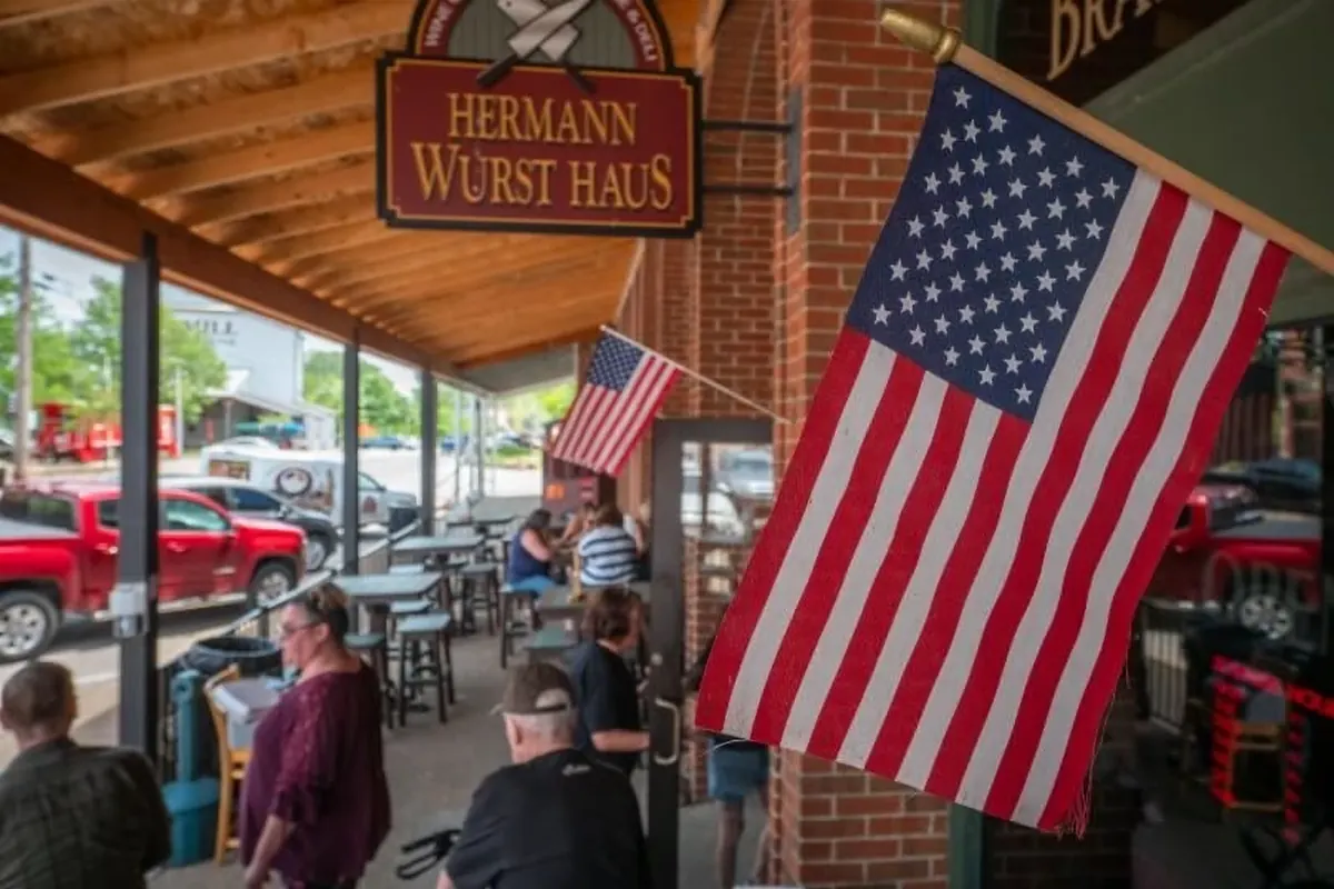Guests dining on the covered patio outside Hermann Wurst Haus on East First Street