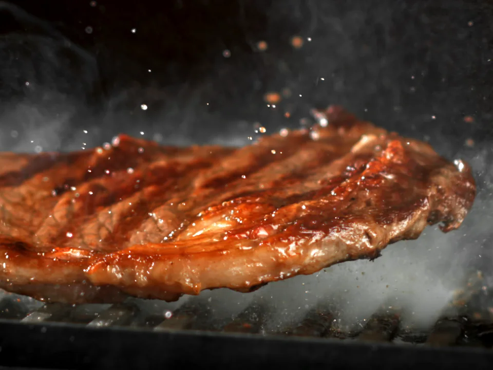 A dry-aged ribeye searing on the grill